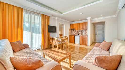 Olohuone, jossa on kaksi sohvaa, sohvapöytä, ruokailutila ja avoin keittiö. (Tekoälyn luoma teksti)