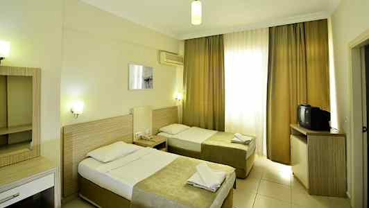 Hotellihuone, jossa kaksi erillistä vuodetta, kirjoituspöytä ja televisio. (Tekoälyn luoma teksti)