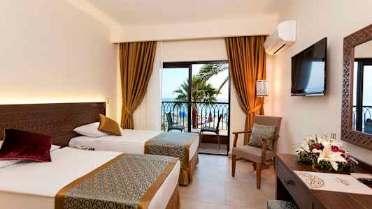 Hotellihuone, jossa kaksi erillistä vuodetta ja ikkuna näkymällä palmuihin ja merelle. (Tekoälyn luoma teksti)