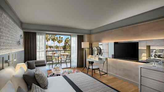 Moderni hotellihuone parvekkeella ja näkymä palmuihin. (Tekoälyn luoma teksti)