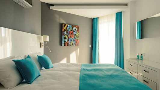 Moderni makuuhuone parivuoteella, turkooseilla yksityiskohdilla ja vaaleilla huonekaluilla. (Tekoälyn luoma teksti)