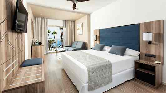 Huone, jossa parivuode, istuinkalusteet ja parveke merinäköalalla. (Tekoälyn luoma teksti)