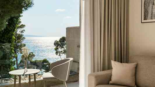 Valoisa ja moderni hotellihuone, josta on merinäköala parvekkeelta. (Tekoälyn luoma teksti)