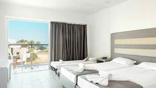 Hotellihuone, jossa on kaksi pedattua sänkyä ja parveke näkymällä. (Tekoälyn luoma teksti)