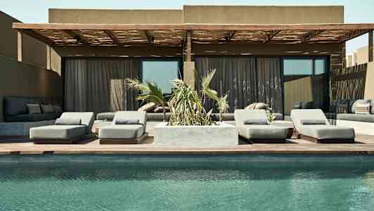 Kuva uima-altaasta terassin edessä, jossa on aurinkotuoleja ja sohvaryhmä. (Tekoälyn luoma teksti)