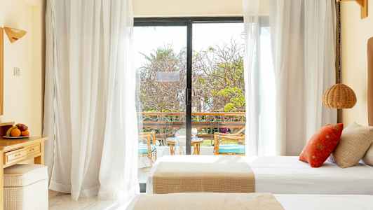 Hotellihuone, jossa on parivuode ja lasiovi, joka johtaa parvekkeelle. (Tekoälyn luoma teksti)