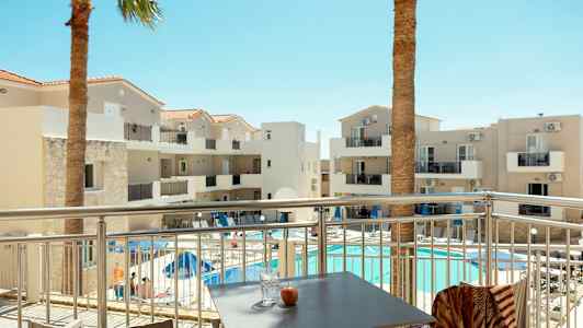 Hotellirakennus parvekkeineen ja uima-altaineen, nähtynä terassilta. (Tekoälyn luoma teksti)