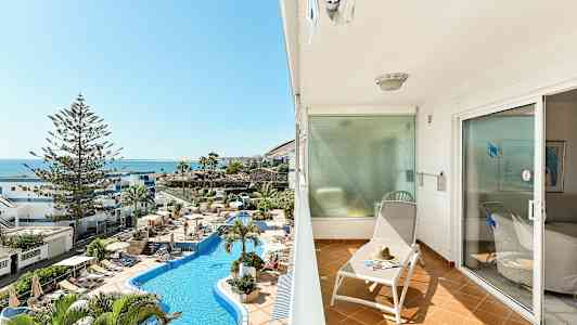 Parveke aurinkotuolilla ja näkymä uima-allasalueelle ja merelle. (Tekoälyn luoma teksti)