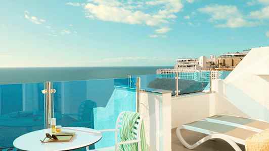 Terassi, jolta on näkymä merelle ja taustalla oleviin rakennuksiin. (Tekoälyn luoma teksti)