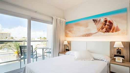 Hotellihuone, parveke ja näkymä, sänky ja rantateemainen sisustus. (Tekoälyn luoma teksti)