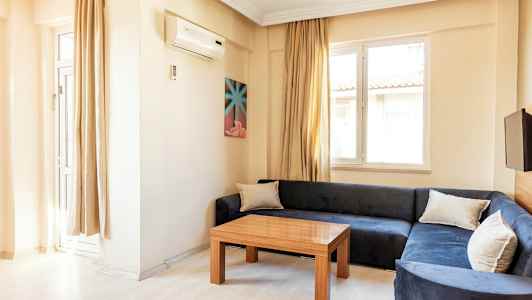 Olohuone, jossa sininen sohva, puupöytä ja kaksi ikkunaa. (Tekoälyn luoma teksti)