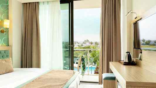 Hotellihuone, jossa parveke ja näkymä uima-allasalueelle. (Tekoälyn luoma teksti)