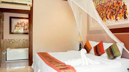 Makuuhuone, jossa koristeellinen hyttysverkko parivuoteen yllä, värikkäät tyynyt ja taidetta seinillä. (Tekoälyn luoma teksti)