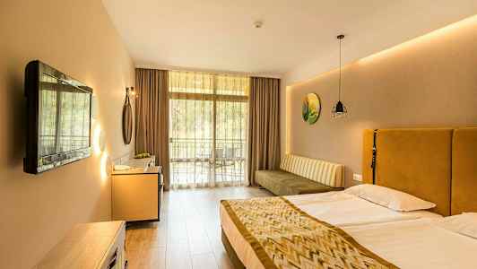 Hotellihuone, jossa on parivuode, sohva, televisio ja parveke. (Tekoälyn luoma teksti)