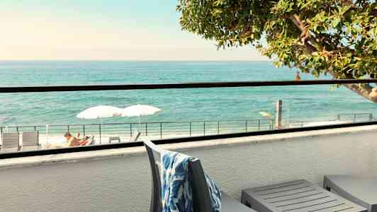 Terassi merinäköalalla, aurinkotuoleja ja varjoja näkyvissä. (Tekoälyn luoma teksti)