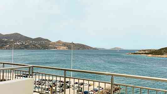 Näkymä parvekkeelta merelle, taustalla näkyy vuoria. (Tekoälyn luoma teksti)