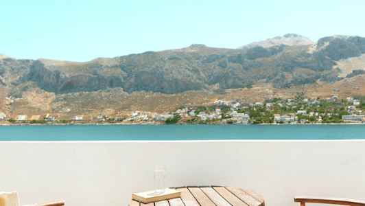 Kaksi tuolia ja pöytä parvekkeella, näkymä järvelle ja vuorille. (Tekoälyn luoma teksti)