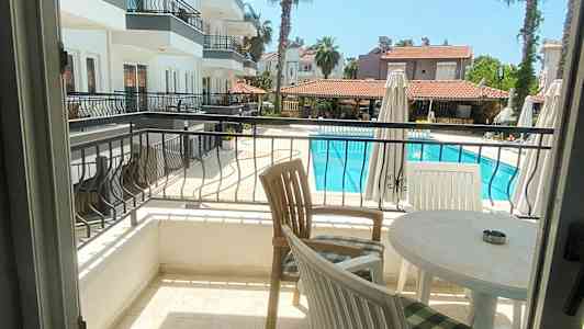 Näkymä parvekkeelta uima-altaalle ja viereisiin rakennuksiin. (Tekoälyn luoma teksti)