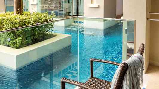 Parveke, josta on näkymä uima-altaalle ja ympäröiviin rakennuksiin. (Tekoälyn luoma teksti)