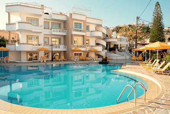 Kuva hotellista, jonka edessä on uima-allas ja aurinkotuoleja. (Tekoälyn luoma teksti)