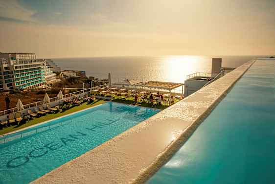 Ulkouima-allas aurinkotuoleilla ja merinäkymällä auringonlaskun aikaan. (Tekoälyn luoma teksti)