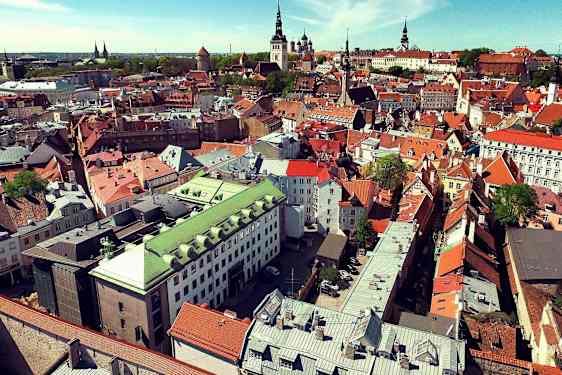 Kaupunkinäkymä ilmasta, jossa on vanhoja erivärisiä rakennuksia. (Tekoälyn luoma teksti)