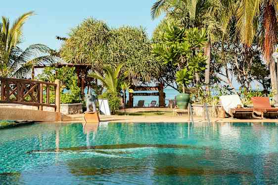 Uima-allas, jonka vieressä on aurinkotuoleja, ja taustalla on puita sekä kyltti tekstillä 'Lanta Villa'. (Tekoälyn luoma teksti)