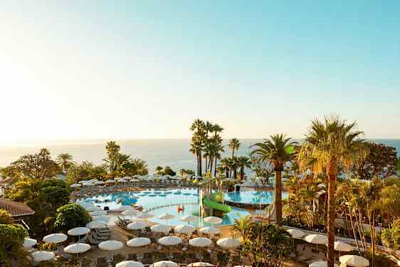 Ulkouima-allas, jonka ympärillä aurinkotuoleja ja palmuja, näkymä merelle. (Tekoälyn luoma teksti)