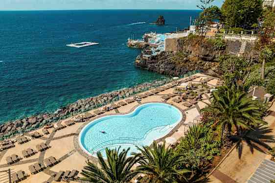 Suljettu uima-allas aurinkotuolien ja merinäköalan kera. (Tekoälyn luoma teksti)