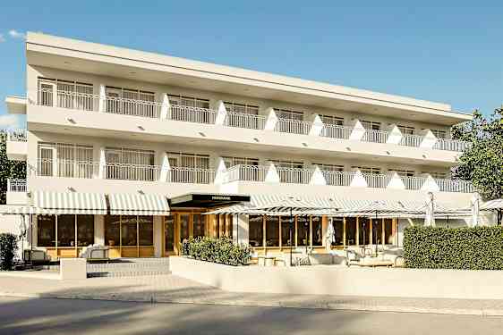 Kolmekerroksinen rakennus, jossa parvekkeet ja sisäänkäynti valkoisin markiisein. (Tekoälyn luoma teksti)