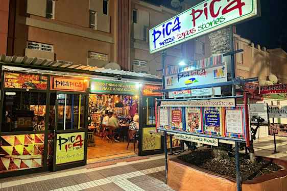 Ravintola Pica Pica näkyy yöllä. Ulkopuolella on kylttejä ja ruokalistoja. (Tekoälyn luoma teksti)