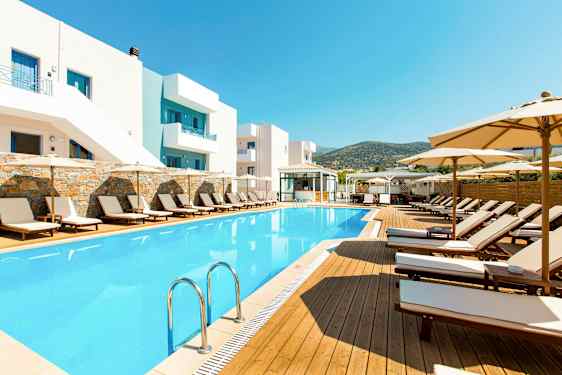 Ulkoallas ja aurinkotuoleja hotellin rakennuksen vieressä. (Tekoälyn luoma teksti)