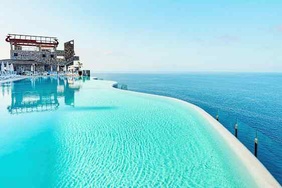 Infinity-allas kirkkaalla sinisellä vedellä ja näkymä merelle. (Tekoälyn luoma teksti)