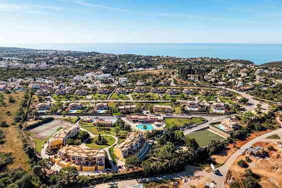 Ilmakuva lomakohteesta, jossa huviloita, uima-allas ja merinäköala. (Tekoälyn luoma teksti)