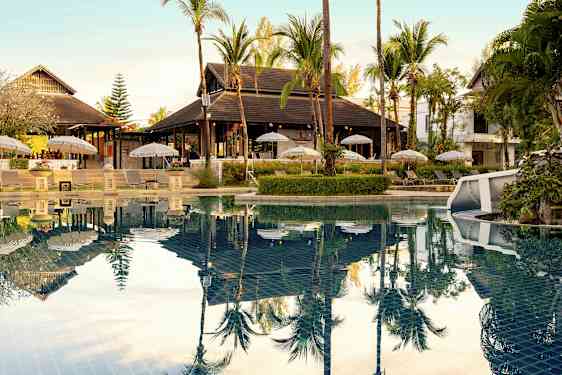 Ulkouima-allas, jonka vieressä on aurinkotuoleja ja aurinkovarjoja sekä ympäröivää trooppista kasvillisuutta. (Tekoälyn luoma teksti)