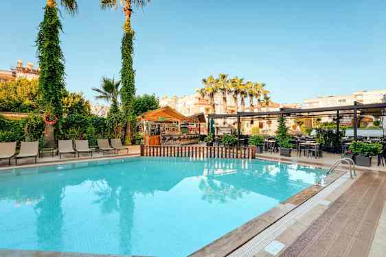 Ulkouima-allas, jossa aurinkotuoleja, puita ja baari taustalla. (Tekoälyn luoma teksti)