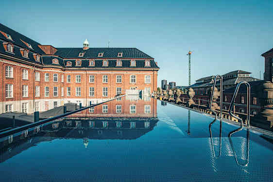 Kattoallas, jolta on näkymä vanhaan tiilirakennukseen. (Tekoälyn luoma teksti)
