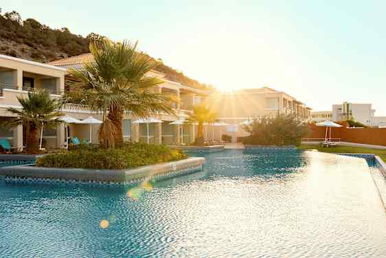 Ulkoallas lomakeskuksessa, taustalla palmuja. (Tekoälyn luoma teksti)