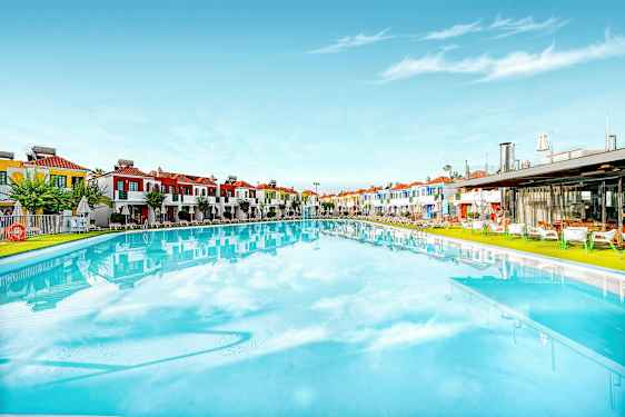 Suuri uima-allas, taustalla värikkäitä rakennuksia. (Tekoälyn luoma teksti)