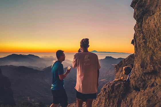 Kaksi ihmistä katselee vuorinäkymää auringonlaskun aikaan. (Tekoälyn luoma teksti)