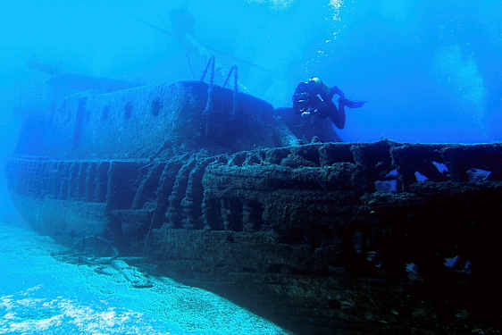 Sukelluskuva uponneesta laivasta, jonka vieressä ui sukeltaja. (Tekoälyn luoma teksti)