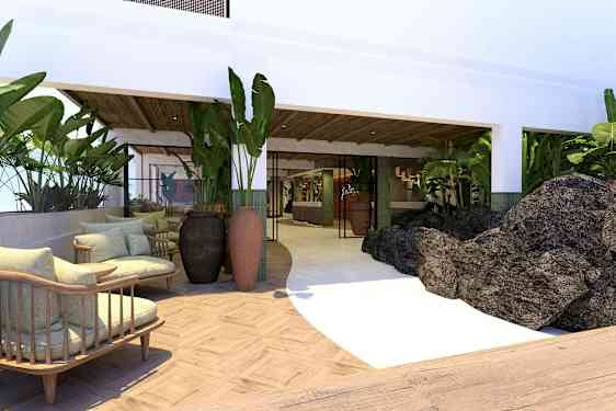 Hotellialue, jossa on istumapaikkoja, kasveja ja kiviä. (Tekoälyn luoma teksti)