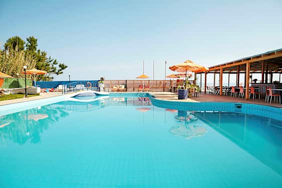 Ulkouima-allas, jonka vieressä on aurinkovarjoja ja pöytiä. (Tekoälyn luoma teksti)