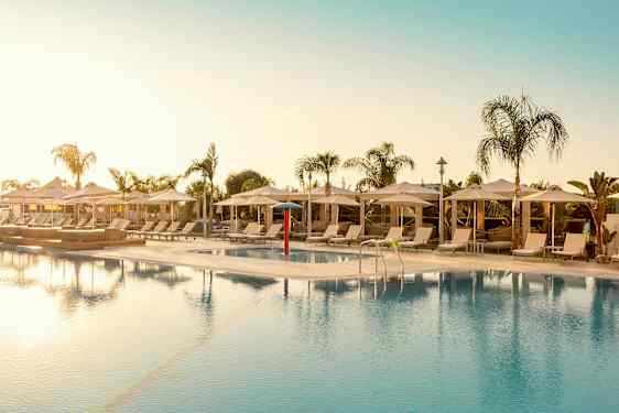 Ulkouima-allas aurinkotuolien ja päivänvarjojen ympäröimänä. (Tekoälyn luoma teksti)