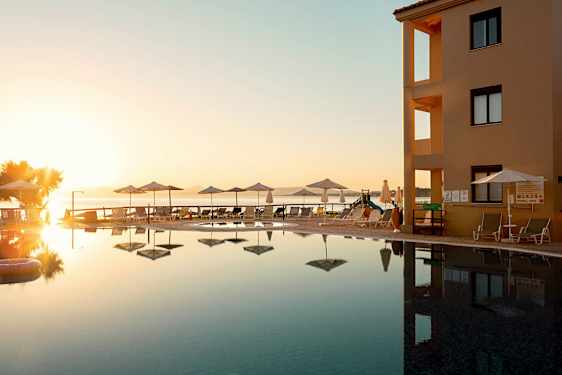 Uima-allasalue rakennuksen vieressä meren äärellä ilta-auringon aikaan. (Tekoälyn luoma teksti)