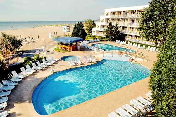 Hotelliallas, aurinkotuoleja ja ranta taustalla. (Tekoälyn luoma teksti)