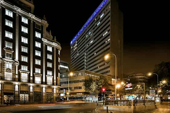 Kaupunkikatu yöllä valaistujen rakennusten ja valokylttien kanssa. (Tekoälyn luoma teksti)