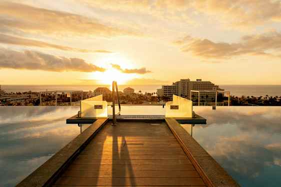 Infinity-allas puusillalla ja näkymä merelle auringonlaskun aikaan. (Tekoälyn luoma teksti)