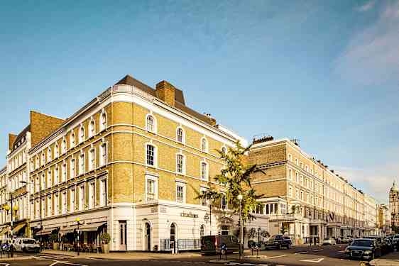 Katu, jossa on rivi klassisia rakennuksia ja pysäköityjä autoja. (Tekoälyn luoma teksti)