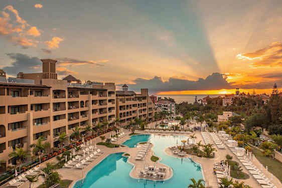 Näkymä hotellista ja uima-allasalueesta auringonlaskun aikaan. (Tekoälyn luoma teksti)